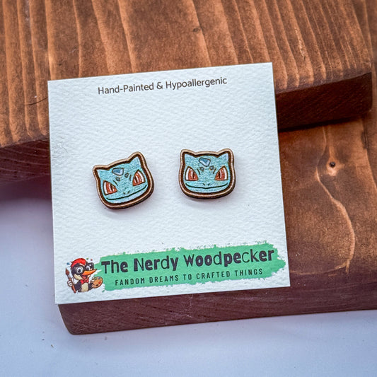 a pair of earrings with a blue and orange design, placed on a white card with text and a cartoon character.