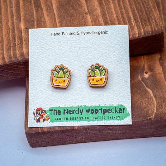 a pair of hand-painted and hypoallergenic earrings with a wooden design, placed on a wooden surface.