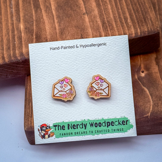 a pair of hand-painted and hypoallergenic earrings displayed on a wooden surface.