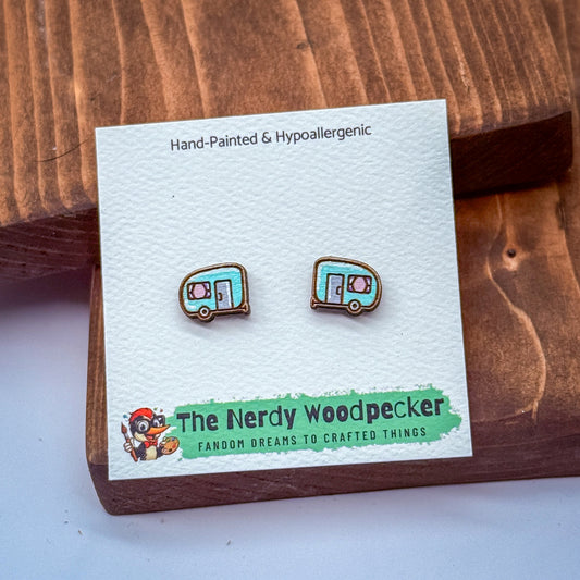 a pair of earrings on a white card with text and a cartoon character illustration.