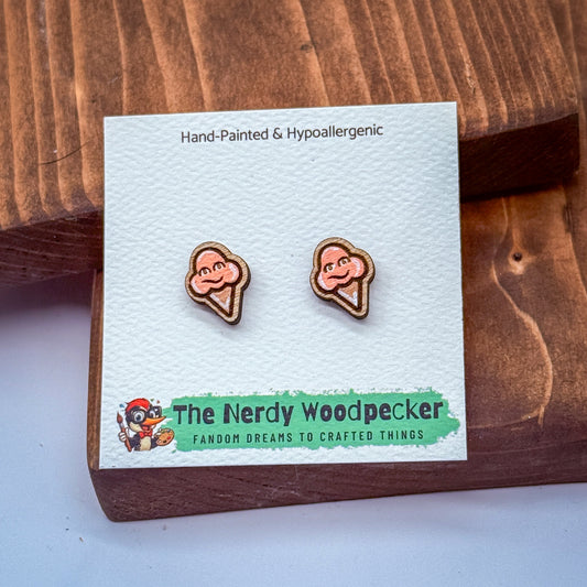 a pair of hand-painted hypoallergenic earrings with a cartoon character design, placed on a white card with text and a logo.