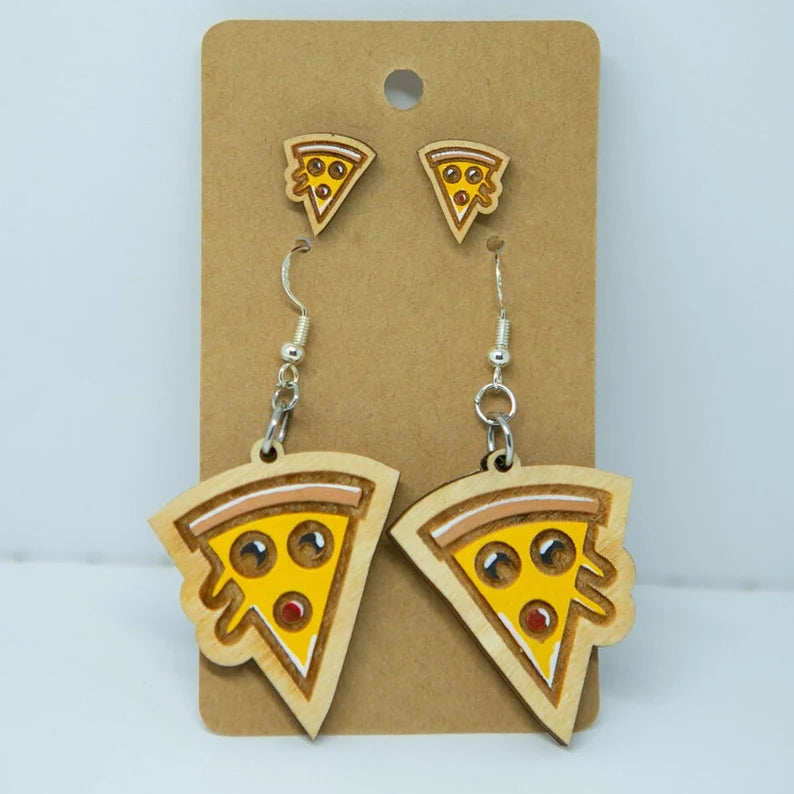 A pair of earrings featuring wooden pizza slice designs, with the earrings and their corresponding pins displayed on a brown card.
