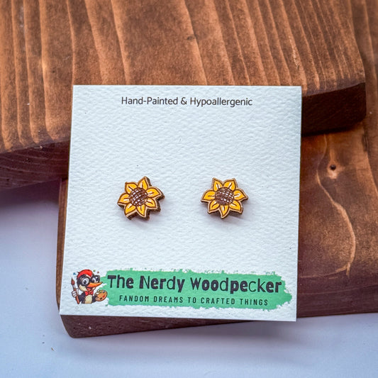 a pair of hand-painted and hypoallergenic earrings from The Nerdy Woodpecker, featuring a wooden design and a cartoon character.
