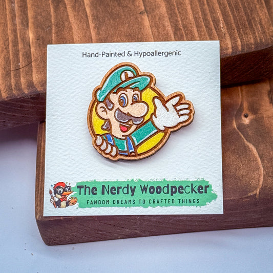 A hand-painted and hypoallergenic pin of a character from the Mario video game franchise, featuring a wooden frame and a green hat.
