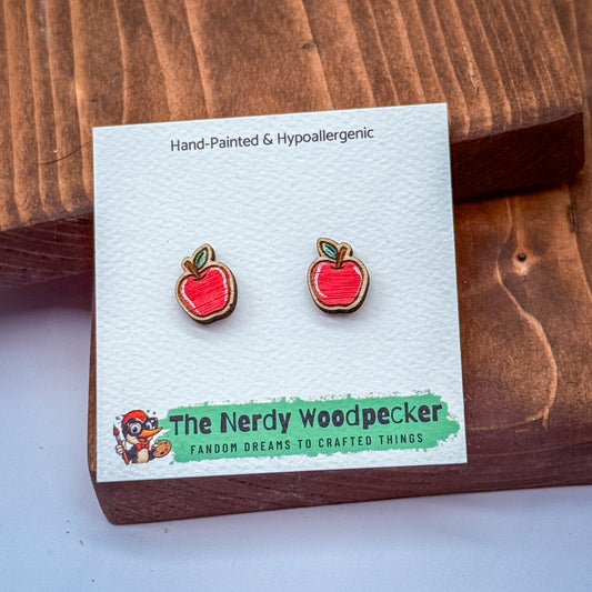 a pair of red earrings with a cartoon character on the packaging, placed on a wooden surface.