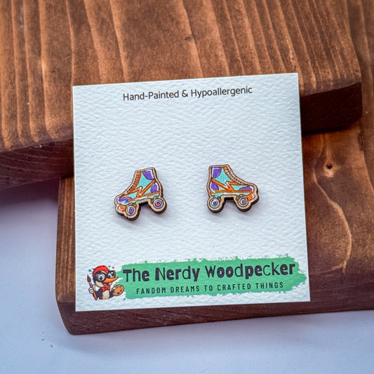 a pair of hand-painted rollerblades earrings displayed on a wooden surface.