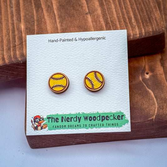 a pair of earrings with a baseball design, displayed on a white card with text and a cartoon character.