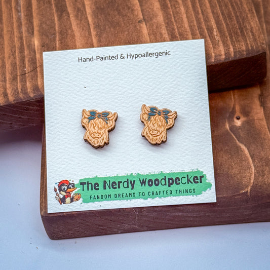 a pair of hand-painted wooden earrings with a hypoallergenic design, displayed on a wooden surface.